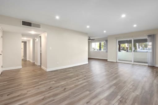 Encino Apartments For Rent - White Oak Terrace - Interior View Of Livingroom Featuring Recess Lights, Large Windows And Wooden Flooring Adjacent To Hallway And Kitchen