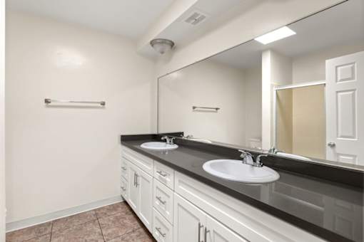 A bathroom with two sinks and a large mirror at White Oak Terrace Apartments, California, 91316