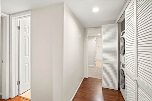 A hallway with a closet and washer and dryer. at White Oak Terrace Apartments, California, 91316