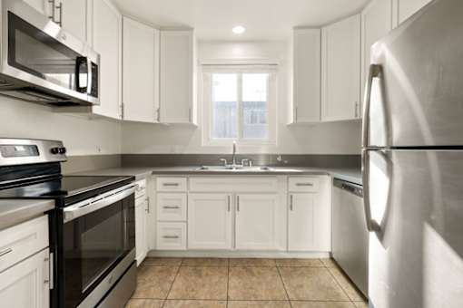 A kitchen with white cabinets and stainless steel appliances.
