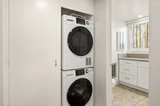 A white front loading washing machine in a laundry room.