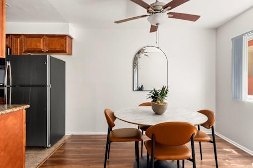 A dining room with a round table and chairs.