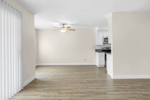 A room with a ceiling fan and a microwave.