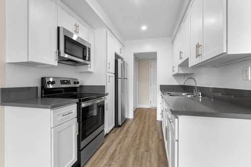 A modern kitchen with white cabinets and stainless steel appliances.
