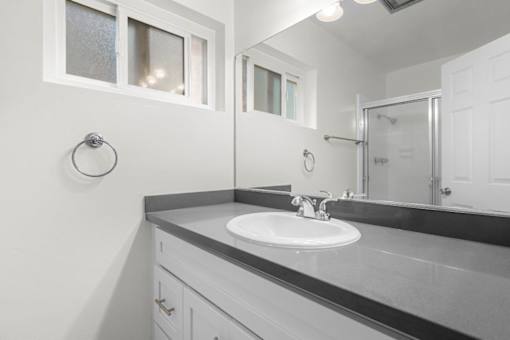 A bathroom with a sink and mirror.