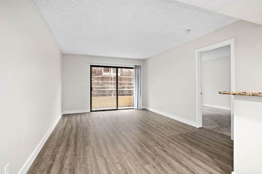 an empty living room with a patio door at Woodland Trio Apartments, North Hollywood, CA