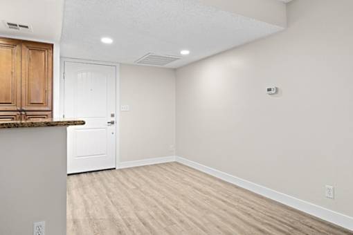 a kitchen and dining room with white walls and wood floors at Woodland Trio Apartments, North Hollywood