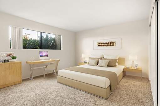 A bedroom with a bed, desk, and chair.