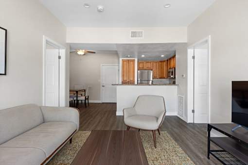 a living room and kitchen with a couch and a chair at Woodland Trio Apartments, North Hollywood