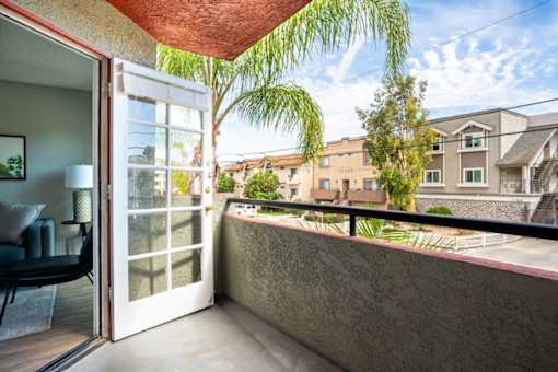 A balcony with a chair and a view of a residential area.