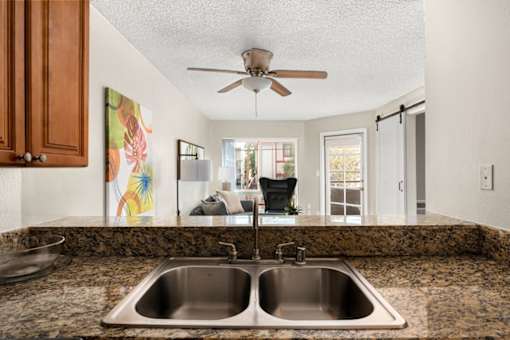 A kitchen with a double sink and a ceiling fan.