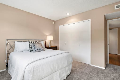 Three-Bedroom Apartments in Encino, CA - White Oak Terrace- Steel Bedframe, Wood-Style Night Stand, Carpeted Floors, and White Bifold Closet Doors