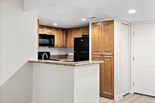 a kitchen with a counter top and a refrigerator at Woodland Trio Apartments, North Hollywood, CA