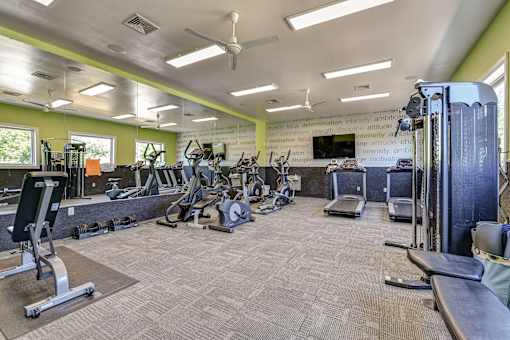 A spacious gym with a variety of equipment including treadmills, weights, and exercise machines.