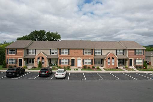 A large brick building with a parking lot in front.