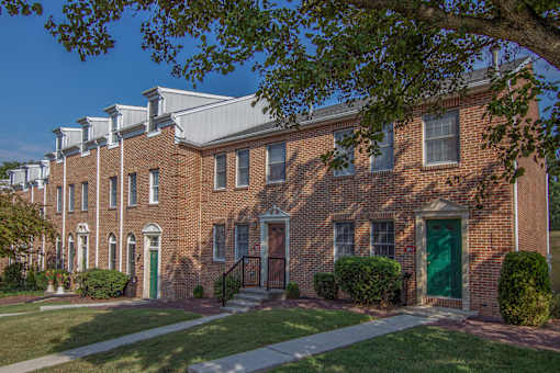 A row of red brick houses with green doors.