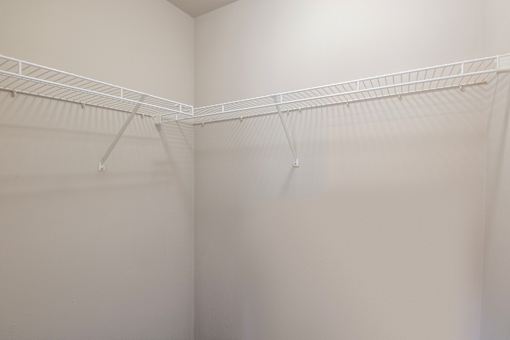 A white closet with a metal rod.
