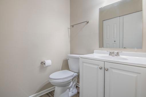 A white toilet sits next to a sink in a bathroom.