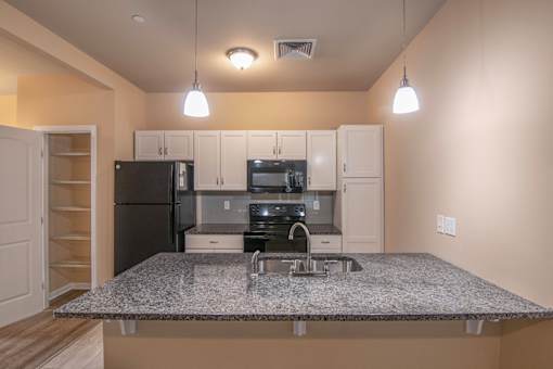A kitchen with granite countertops and stainless steel appliances.