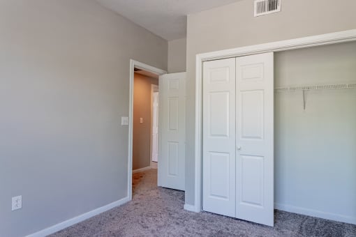 a bedroom with two closets and an open door