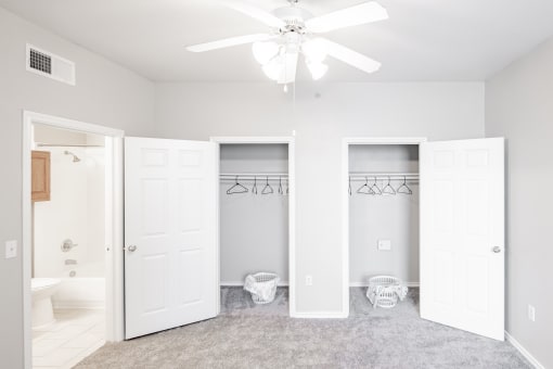 a bedroom with two closets and a ceiling fan