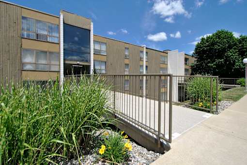 A building with a metal fence and plants in front.