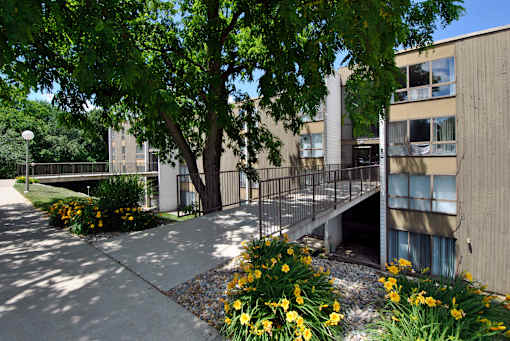 A concrete building with a tree in front of it.