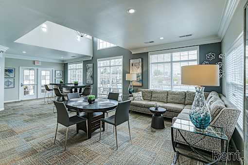 A well-lit living room with a dining table and chairs at Abbey Ridge Apartment Homes, Oxford, Michigan