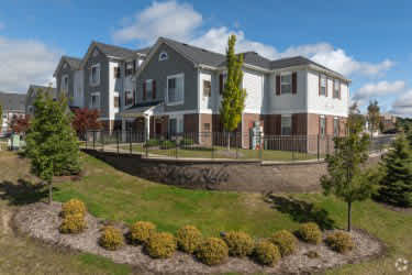 A large, modern building with a landscaped front yard at Abbey Ridge Apartment Homes, Oxford, MI, Michigan