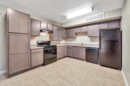 A kitchen with brown cabinets and appliances.