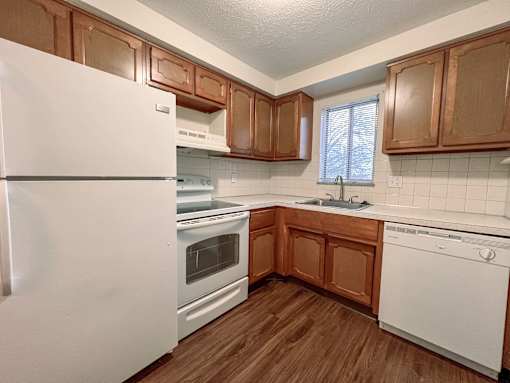 a kitchen with white appliances and wooden cabinets