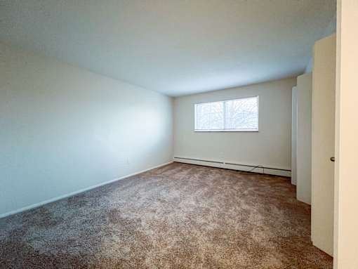 an empty room with carpet and a window