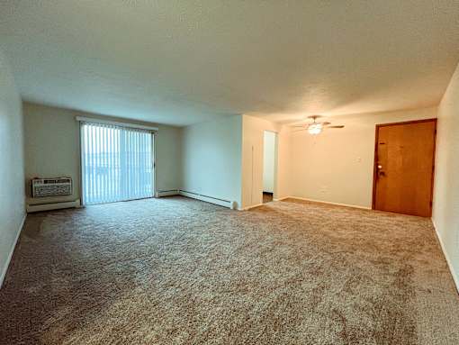 an empty living room with a window and a door