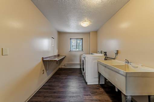 A laundry room with a washer and dryer and a sink.