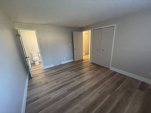 A room with wooden flooring and white walls.