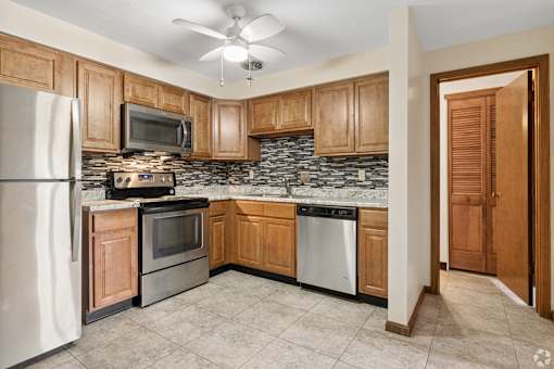 A kitchen with wooden cabinets and a white refrigerator.