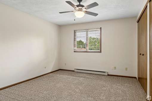 A room with a ceiling fan and a window.