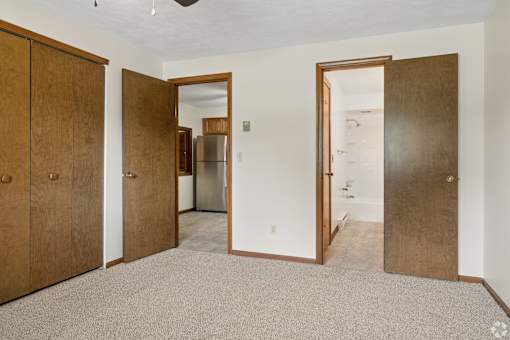 A room with a carpeted floor and a mirror on the wall.