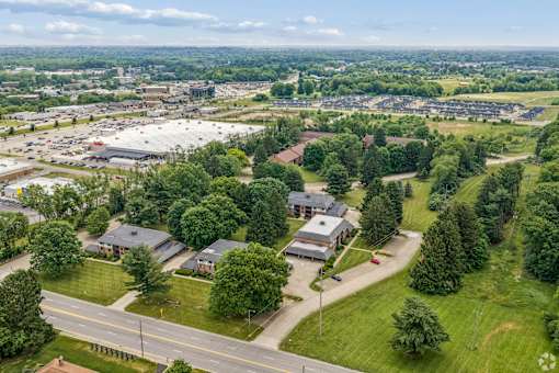 A bird's eye view of a suburban area with houses and a road.