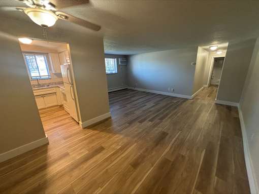 A room with wooden floors and a ceiling fan.