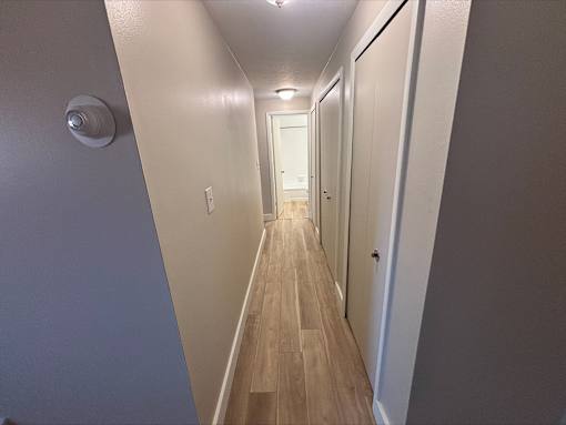 A long hallway with a light on the wall.