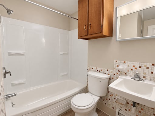 A white toilet sits next to a white sink in a bathroom.