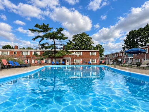 A large blue swimming pool in front of a building with red brick walls.