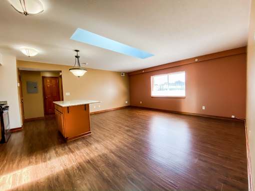 an empty living room with wood floors and a table