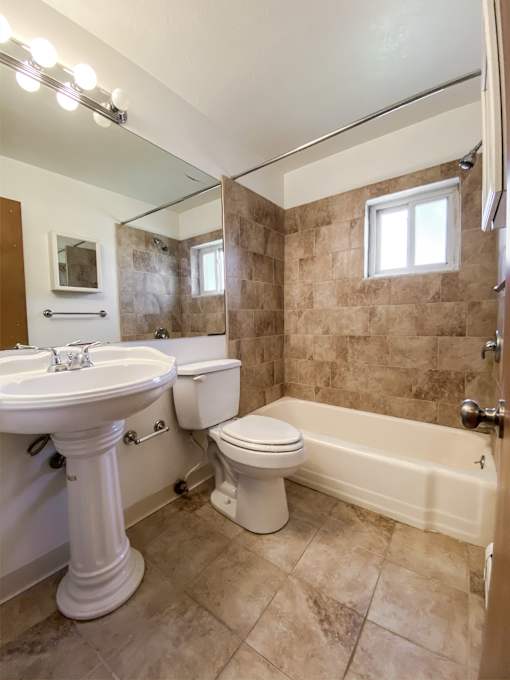 a bathroom with a toilet and a sink and a bath tub