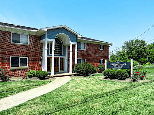 the front of a brick building with a sign in front