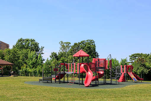 A playground with a red slide and a green lawn at Hummingbird Pointe & The Gardens, Ohio