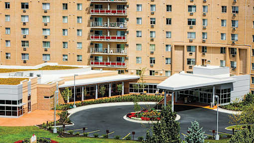 A large building with a green roof and a white covered walkway at Hummingbird Pointe & The Gardens, Parma, 44129