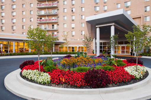 A flower bed in front of a building entrance at Hummingbird Pointe & The Gardens, Parma, OH 44129