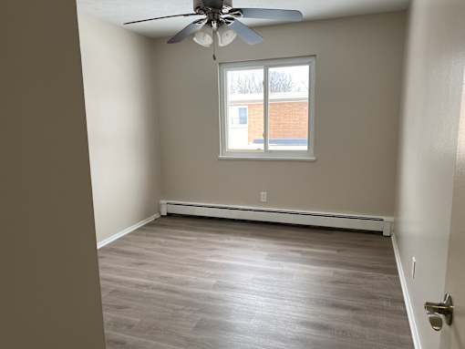 A room with a ceiling fan and a window.